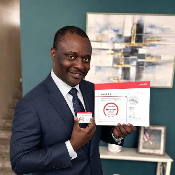 Yannick E. holding his CompTIA Security+ certificate with Did-Acte platform